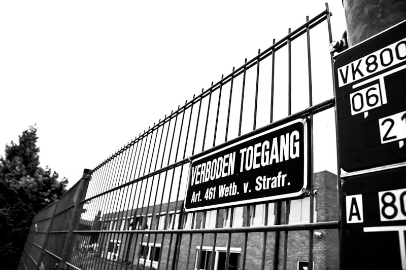 grayscale photography of metal fence